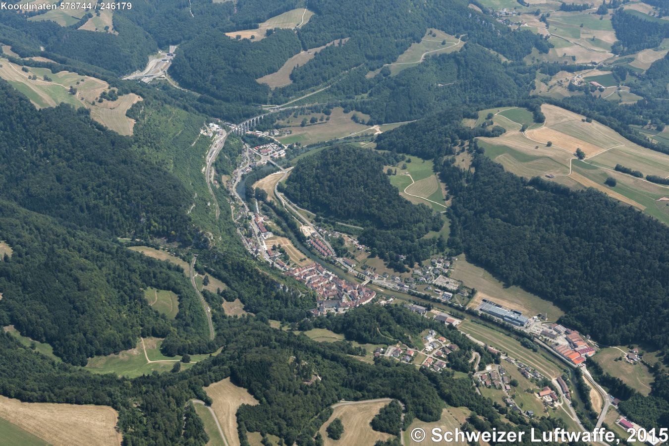 St. Ursanne. Altstadt vorne im Bild. Einsenbahnbrücke (SBB), und Autobahnanschluss A16/E27. Siedlung ganz oben im Bild: Montmelon-Dessus